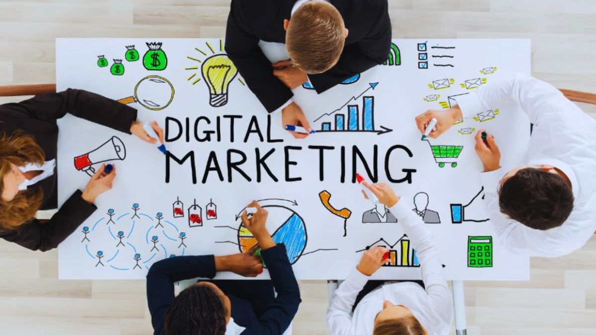 Team brainstorming digital marketing strategy with drawings of charts, graphs, and icons on a table at a digital marketing agency.