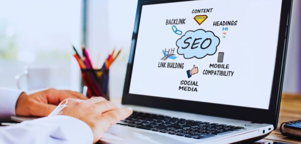 A person working on a laptop displaying an SEO concept diagram with terms like backlink, content, headings, link building, social media, and mobile compatibility, representing the services of an SEO Company in Kendall.